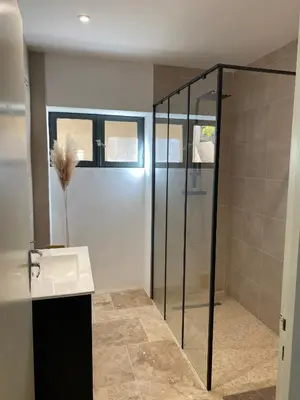 a bathroom with a sink and a glass shower at Confortable T2 avec jardin aménagé in Lézignan-Corbières