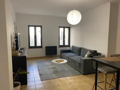 a living room with a couch and a table at Confortable T2 avec jardin aménagé in Lézignan-Corbières