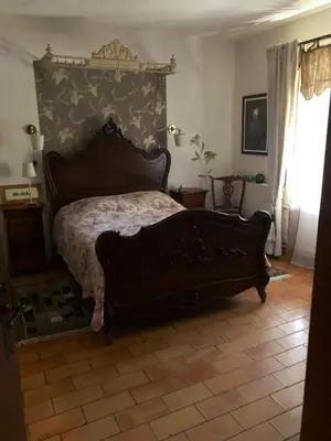 a bedroom with a large bed with a wooden headboard at Maison chaleureuse à Cuxac-Cabardès avec jardin de 3500m² in Cuxac-Cabardès