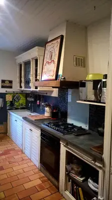 a kitchen with white cabinets and a stove top oven at Maison chaleureuse à Cuxac-Cabardès avec jardin de 3500m² in Cuxac-Cabardès