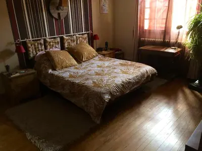 a bedroom with a large bed with a wooden floor at Maison chaleureuse à Cuxac-Cabardès avec jardin de 3500m² in Cuxac-Cabardès