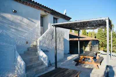 a patio with a wooden table and a wooden bench at Domaine de Gourgounet gîte à la ferme, Gite de groupe 25 couchages avec piscine privative in Villefloure