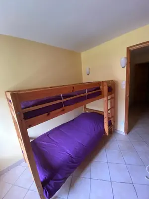 a bunk bed in a room with a purple pillow at Domaine de Gourgounet gîte à la ferme, Gite de groupe 25 couchages avec piscine privative in Villefloure