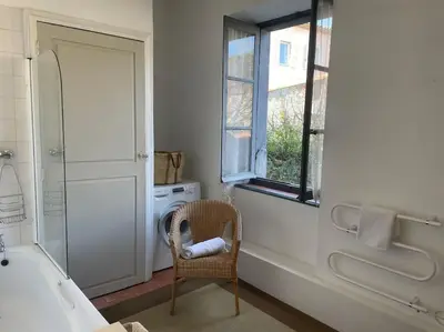 a bathroom with a chair and a tub and a window at The Forge Esperaza in Espéraza