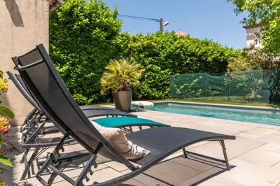 a black chair sitting next to a swimming pool at La Casa Grande - piscine - wifi - parking in Carcassonne