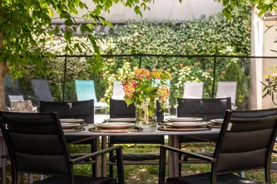 a black table with chairs and a vase of flowers at La Casa Grande - piscine - wifi - parking in Carcassonne