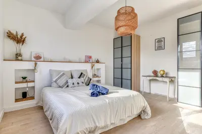 a bedroom with a large white bed in a room at La Casa Grande - piscine - wifi - parking in Carcassonne