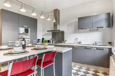 a kitchen with a large island with red chairs at La Casa Grande - piscine - wifi - parking in Carcassonne