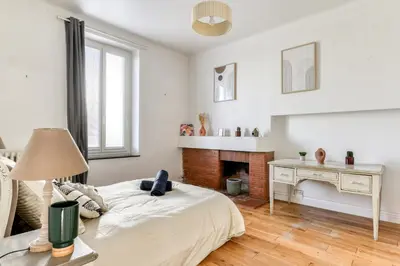 a white bedroom with a bed and a fireplace at La Casa Grande - piscine - wifi - parking in Carcassonne