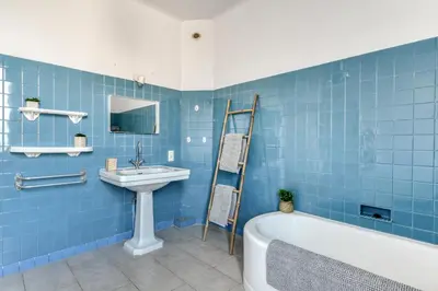 a blue bathroom with a sink and a bath tub at La Casa Grande - piscine - wifi - parking in Carcassonne
