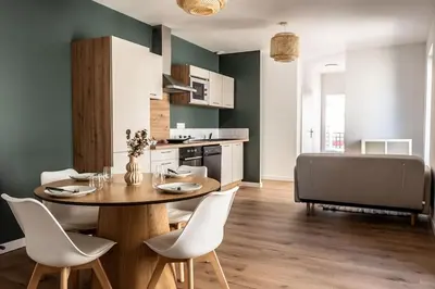 a kitchen and dining room with a table and chairs at T2 Le Miredames in Castres