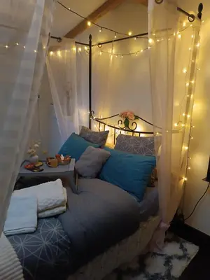 a bedroom with a bed with lights on it at Jolie maison de village in Capendu