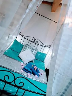 a small child laying on a bed in a bedroom at Jolie maison de village in Capendu