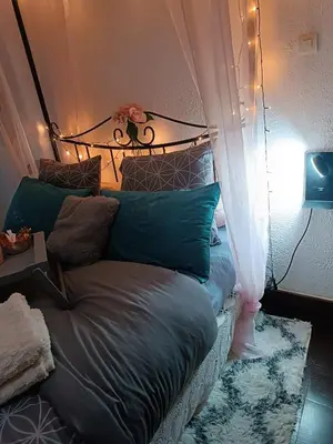 a bedroom with a bed with a headboard and pillows at Jolie maison de village in Capendu