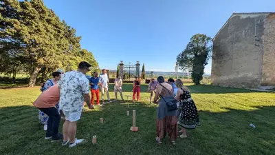 a group of people playing dominoes in a park at Les Cabanes Dans Les Bois Logis Hôtel in Villalier