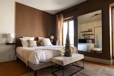 a bedroom with a large bed and a large mirror at L'Évêché/ Clim/ Vue/ Confort in Carcassonne