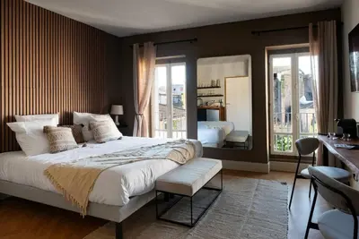 a bedroom with a large bed and a mirror at L'Évêché/ Clim/ Vue/ Confort in Carcassonne