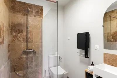 a bathroom with a shower with a toilet and a television at L'Évêché/ Clim/ Vue/ Confort in Carcassonne