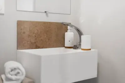a bathroom with a white counter with a light fixture at L'Évêché/ Clim/ Vue/ Confort in Carcassonne