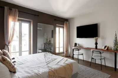 a bedroom with a bed and a desk and a television at L'Évêché/ Clim/ Vue/ Confort in Carcassonne