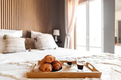 two loaves of bread on a tray on a bed at L'Évêché/ Clim/ Vue/ Confort in Carcassonne