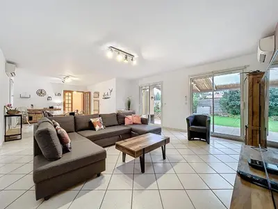 a living room with a couch and a table at La Flemme en Rose- Villa avec piscine-Pet Friendly in Peyriac-de-Mer