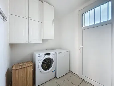a washer and dryer in a white laundry room at La Flemme en Rose- Villa avec piscine-Pet Friendly in Peyriac-de-Mer