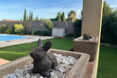 a statue of a rabbit sitting in a flower pot at La Flemme en Rose- Villa avec piscine-Pet Friendly in Peyriac-de-Mer