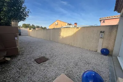 an empty alley with a fence and blue balls at La Flemme en Rose- Villa avec piscine-Pet Friendly in Peyriac-de-Mer