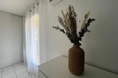 a vase with flowers sitting on a table in a room at La Flemme en Rose- Villa avec piscine-Pet Friendly in Peyriac-de-Mer