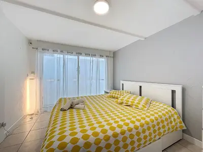 a bedroom with a yellow bed with a stuffed animal on it at La Flemme en Rose- Villa avec piscine-Pet Friendly in Peyriac-de-Mer