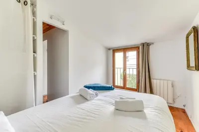 a bedroom with a large white bed with towels on it at Le Patio de la Bastide avec Terrasse & Netflix - Quartier paisible in Carcassonne