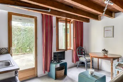 a living room with a table and a window at Le Patio de la Bastide avec Terrasse & Netflix - Quartier paisible in Carcassonne