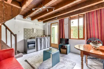 a living room with a table and a kitchen at Le Patio de la Bastide avec Terrasse & Netflix - Quartier paisible in Carcassonne