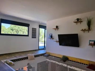 a living room with a flat screen tv on a wall at Le Catamaran in Sallèles-dʼAude