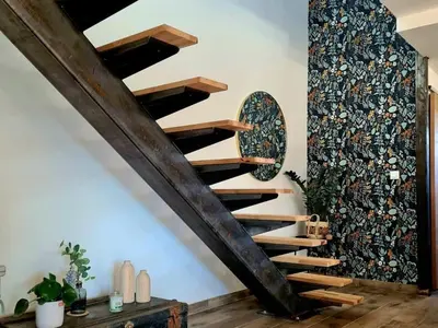 a wooden spiral staircase in a room with a wall at Le Catamaran in Sallèles-dʼAude