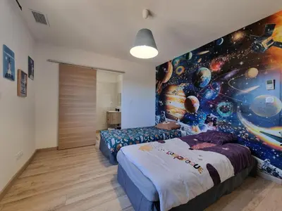 a bedroom with two beds and a painting on the wall at Le Catamaran in Sallèles-dʼAude