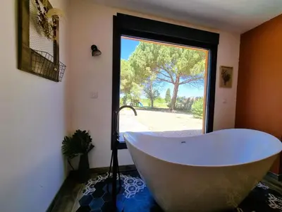 a bath tub in a bathroom with a large window at Le Catamaran in Sallèles-dʼAude