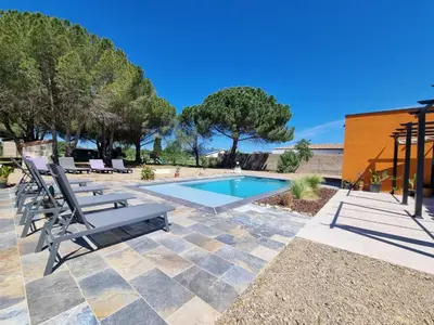 a swimming pool with chaise lounge chairs next to a resort at Le Catamaran in Sallèles-dʼAude