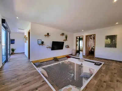 a living room with a table and a tv at Le Catamaran in Sallèles-dʼAude