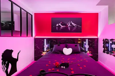 a pink bedroom with a bed with flowers on it at Cachette Secrète & SPA Narbonne in Narbonne