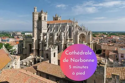 a large cathedral with a purple sign in front of it at Cachette Secrète & SPA Narbonne in Narbonne