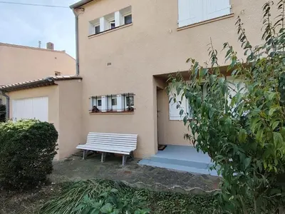 a bench sitting in front of a building at escapade près du lac in Peyriac-de-Mer