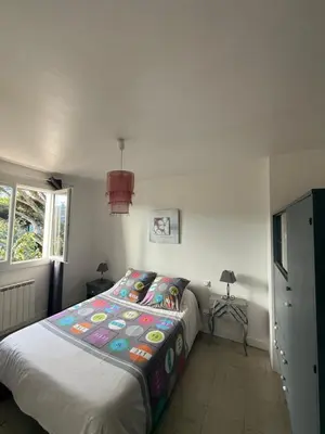 a bedroom with a bed with a colorful comforter at escapade près du lac in Peyriac-de-Mer