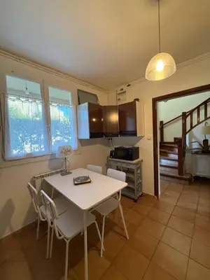 a kitchen with a table and chairs in a room at escapade près du lac in Peyriac-de-Mer