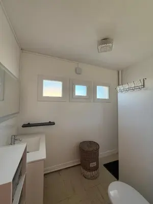 a white bathroom with a toilet and a sink at escapade près du lac in Peyriac-de-Mer