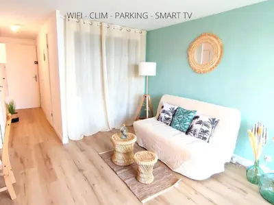 a living room with a white couch and blue walls at L'Escapade : Charmant T2 -Parking gratuit, piscine, wifi, clim in Gruissan