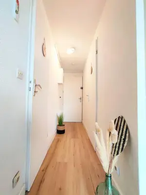 a hallway with a vase of flowers in a room at L'Escapade : Charmant T2 -Parking gratuit, piscine, wifi, clim in Gruissan