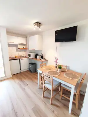 a kitchen and dining room with a table and chairs at L'Escapade : Charmant T2 -Parking gratuit, piscine, wifi, clim in Gruissan