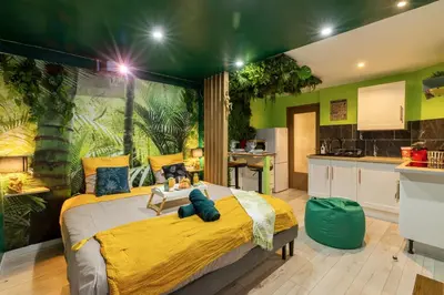 a bedroom with a large bed and a kitchen at Cap Jungle Evasion: Cinema Netflix King size in Limoux